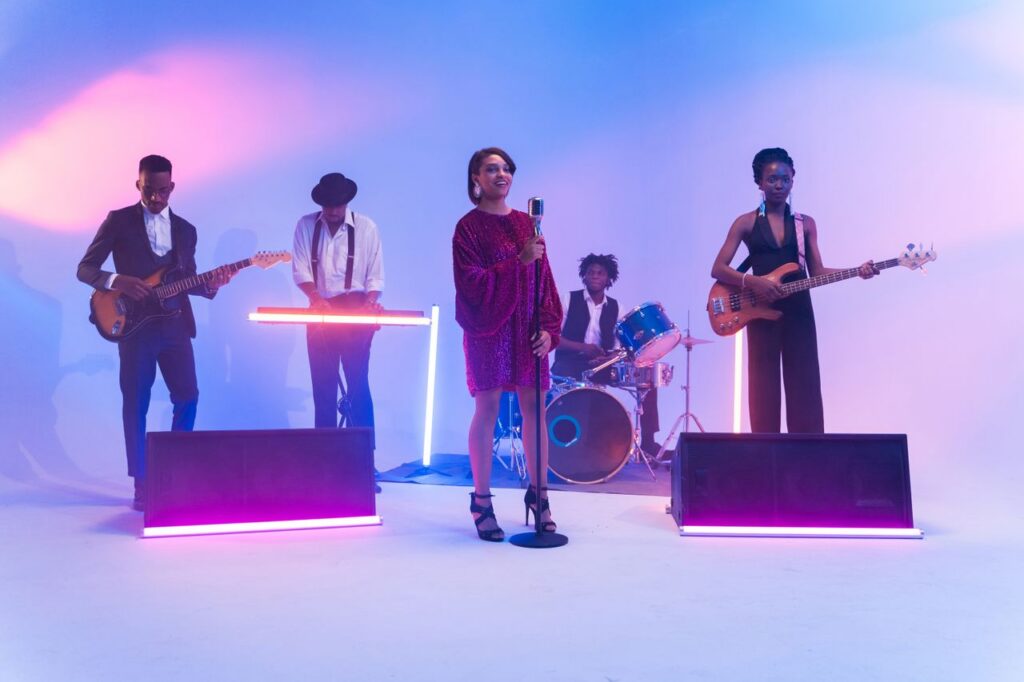 A vibrant band performing on stage with neon lights and musical instruments, showcasing talent and energy.